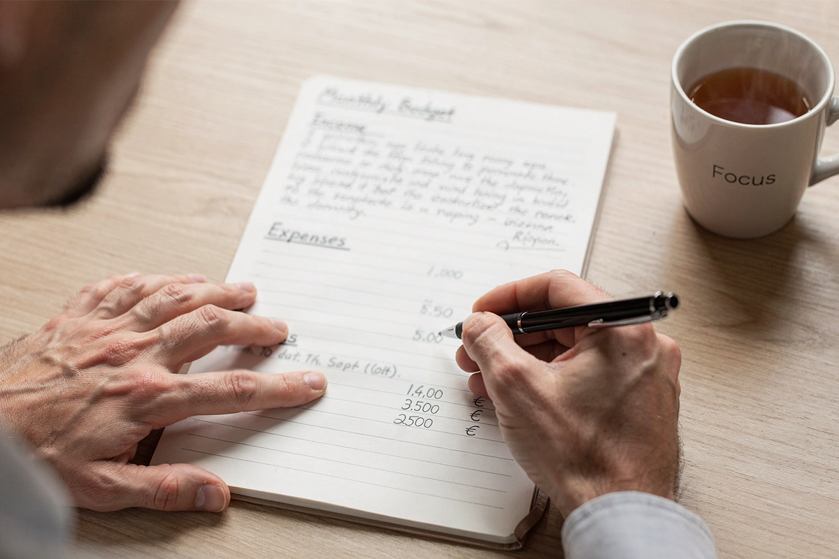 Handen met notitieboek voor budgetbeheer bij sportweddenschappen